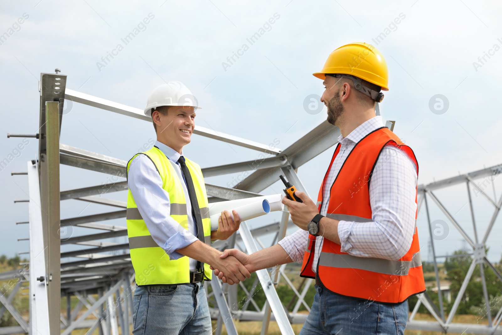 Photo of Professional engineers working on installation of electrical substation outdoors