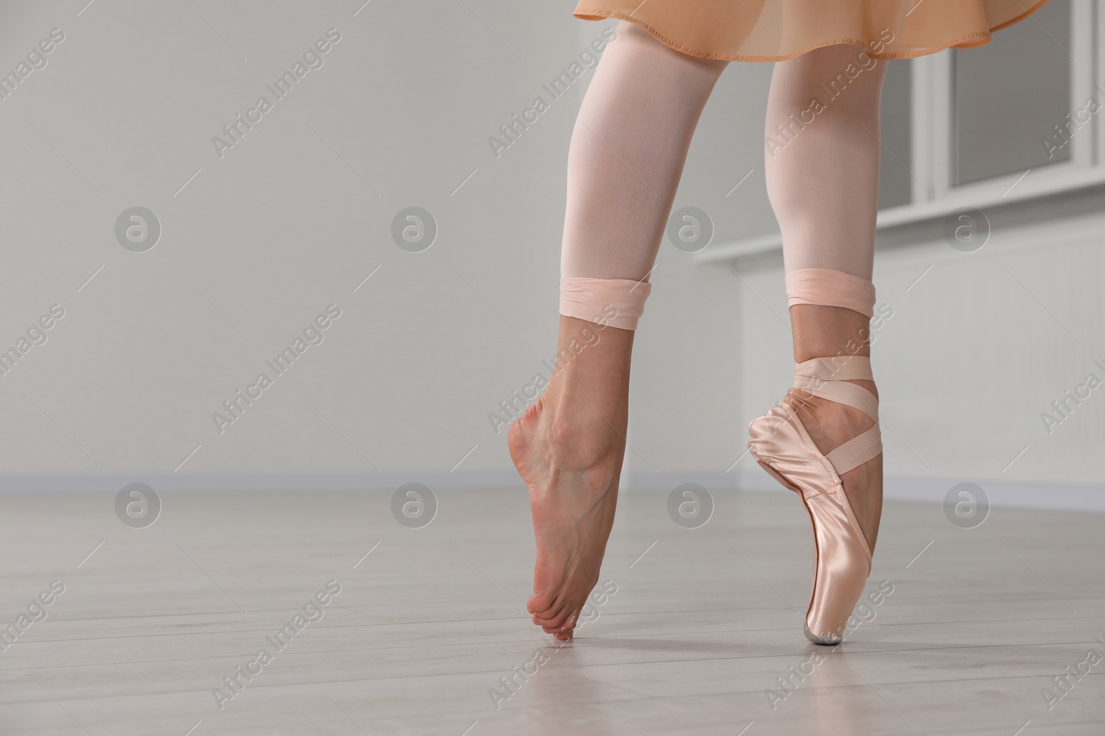 Photo of Ballerina in pointe shoe dancing indoors, closeup. Space for text