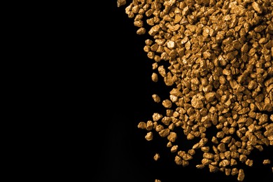 Photo of Pile of gold nuggets on black background, flat lay. Space for text