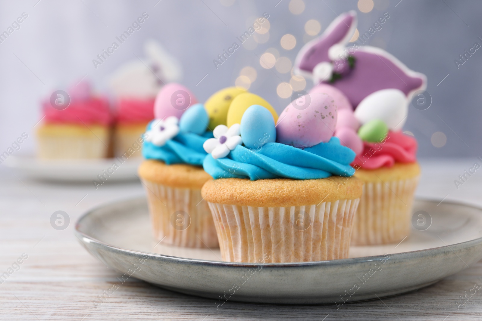 Photo of Tasty decorated Easter cupcakes on wooden table, closeup