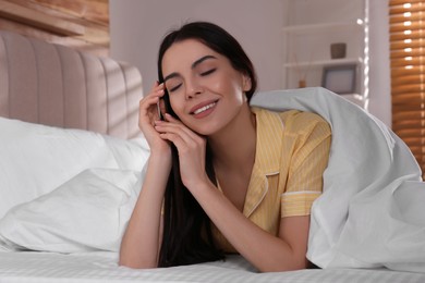 Woman lying in comfortable bed with white linens