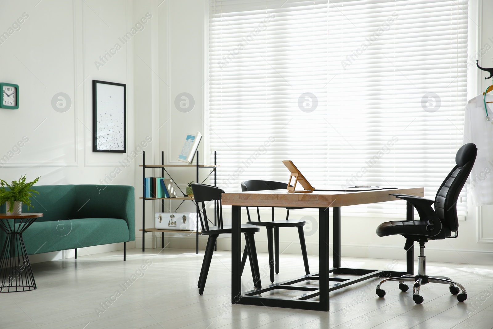 Photo of Modern medical office interior with doctor's workplace and sofa