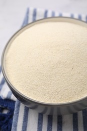 Photo of Bowl of uncooked organic semolina on table, closeup