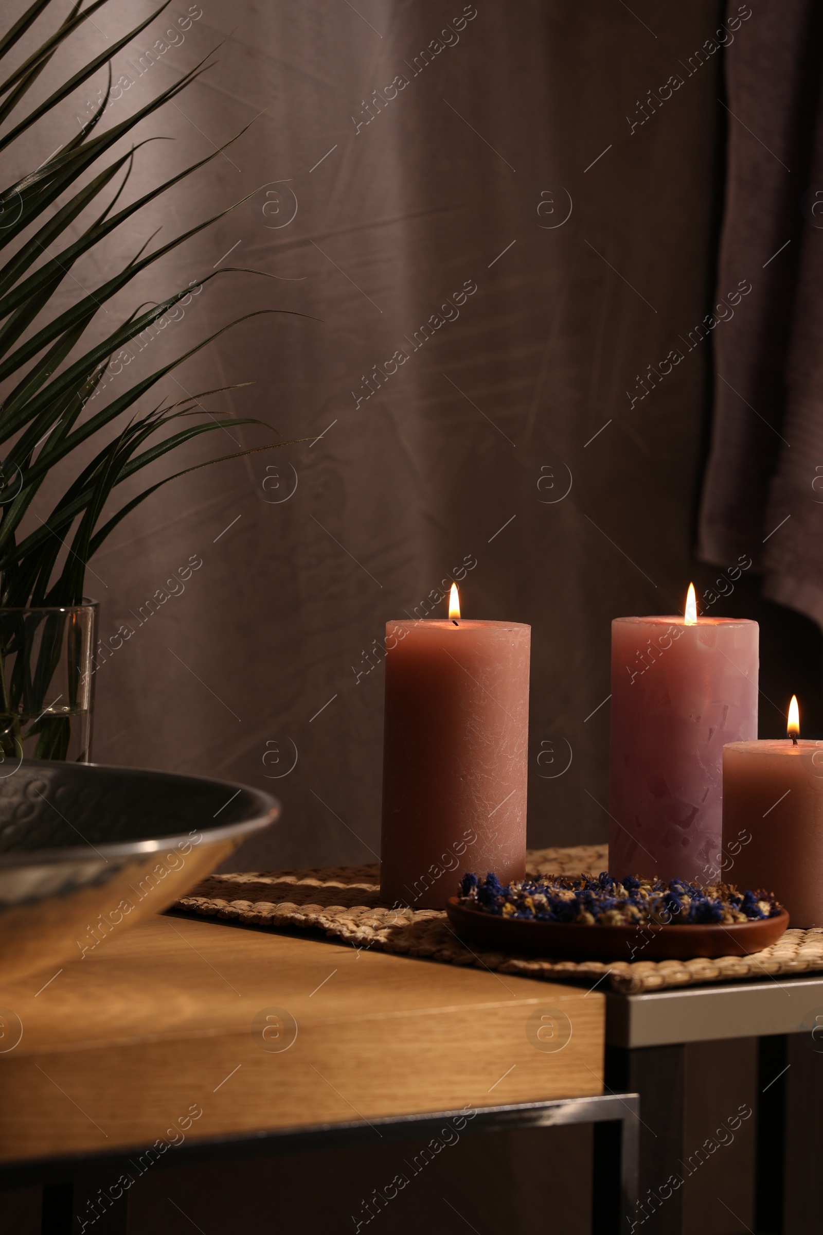 Photo of Spa composition. Burning candles and dry flowers on table indoors