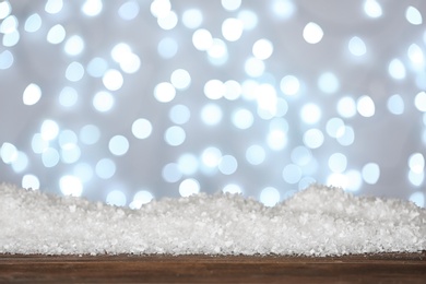 Photo of Heap of snow on wooden surface against blurred background. Christmas season