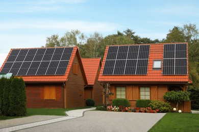Photo of Beautiful houses with solar panels outdoors. Real estate for rent