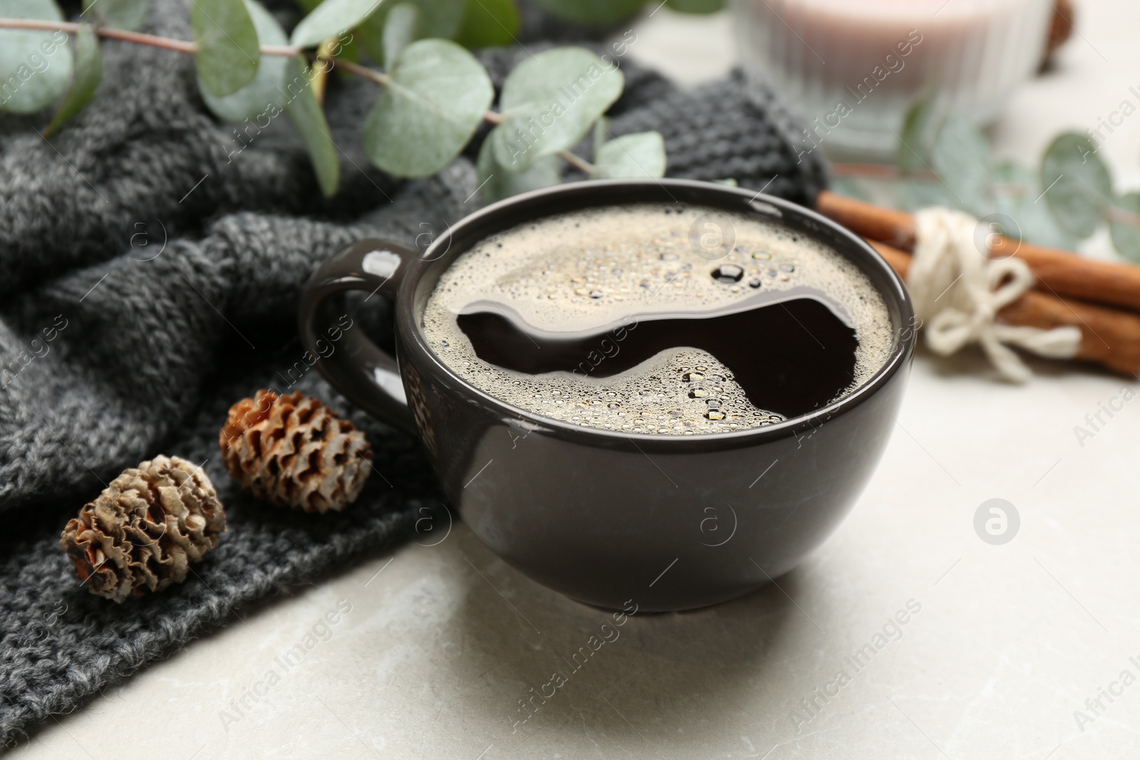 Photo of Composition with hot drink and warm plaid on light marble table, closeup