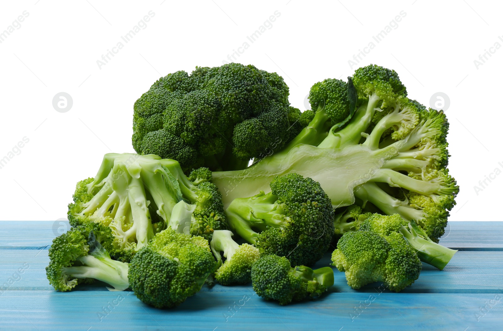 Photo of Fresh broccoli on light blue wooden table against white background