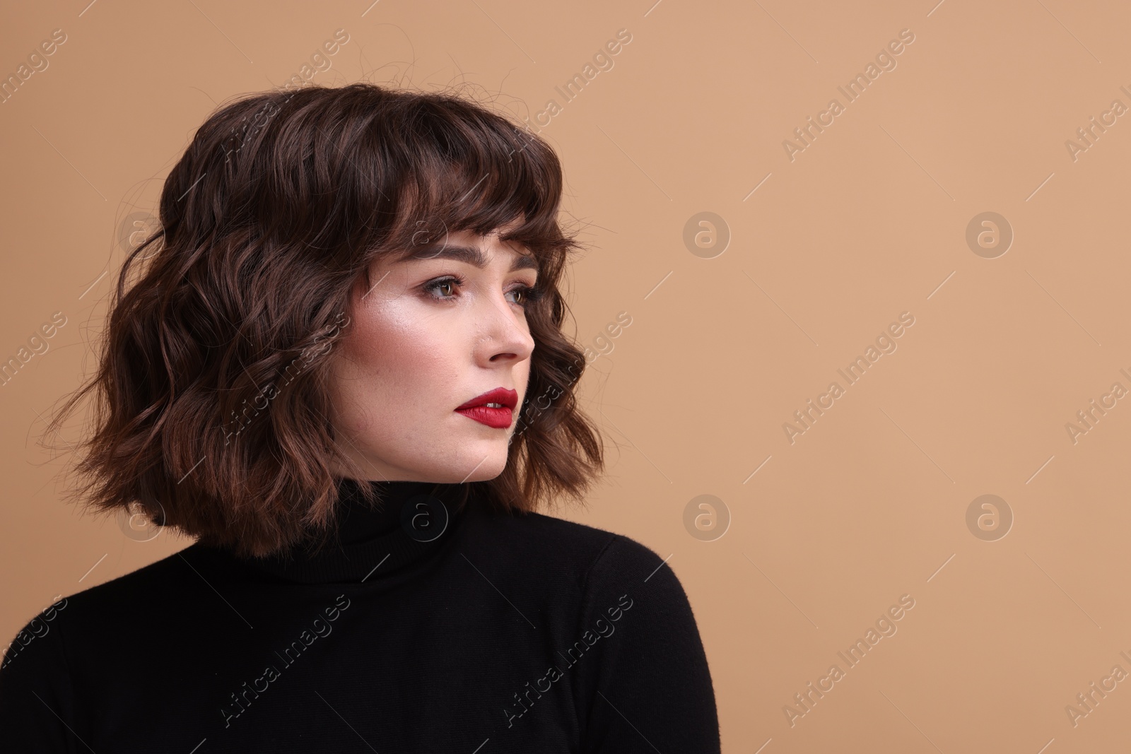 Photo of Portrait of beautiful young woman with wavy hairstyle on beige background. Space for text