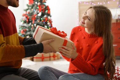 Photo of Happy young couple with Christmas gift box at home