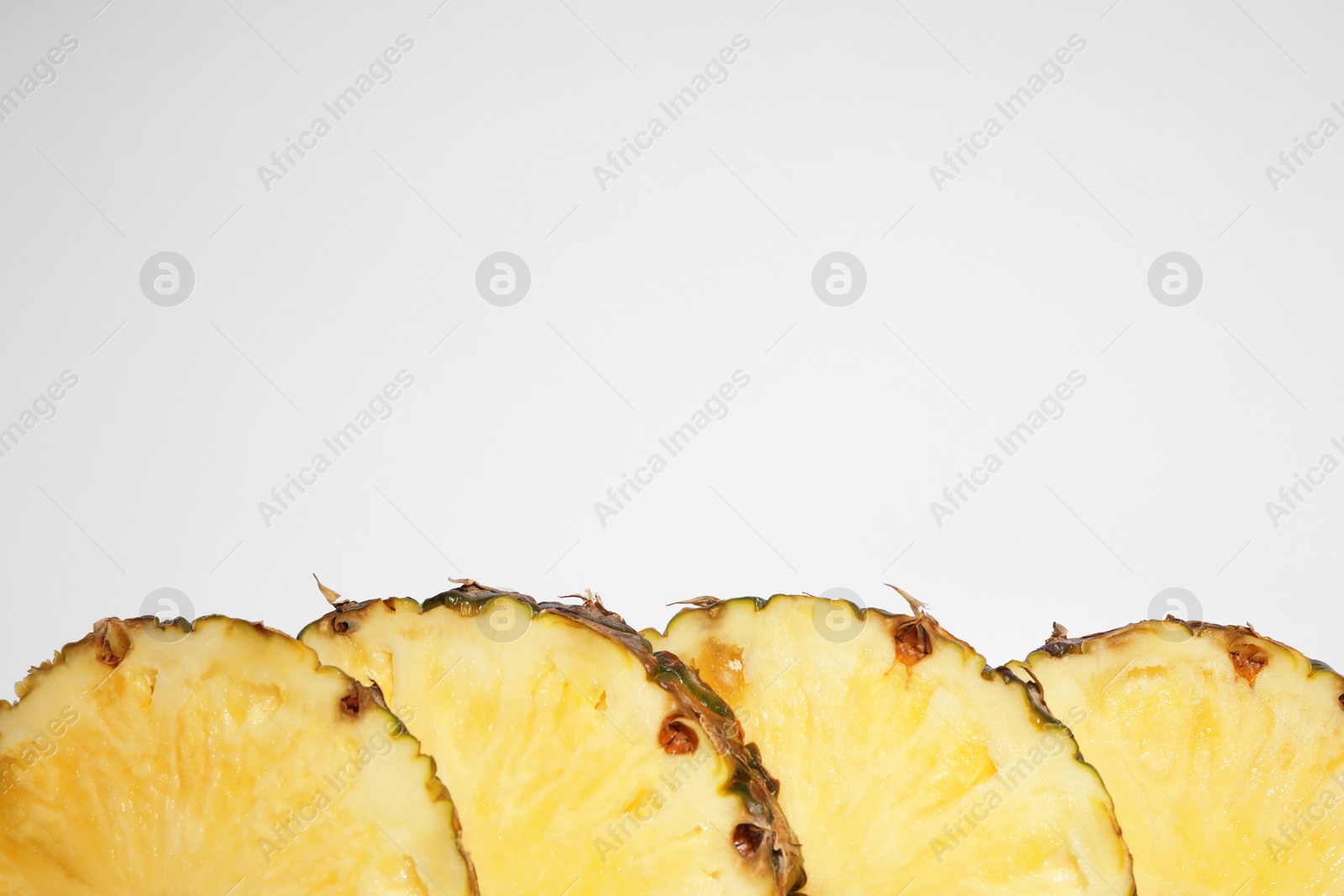 Photo of Slices of tasty ripe pineapple on white background, flat lay. Space for text