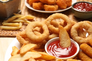 Different snacks and tasty ketchup on table, closeup