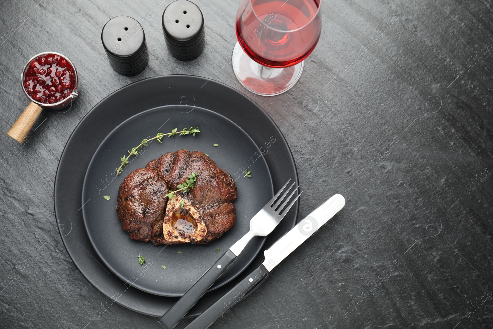 Photo of Tasty grilled beef meat served on black table, flat lay. Space for text