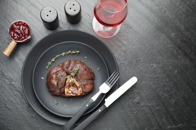 Photo of Tasty grilled beef meat served on black table, flat lay. Space for text