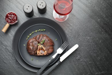 Tasty grilled beef meat served on black table, flat lay. Space for text