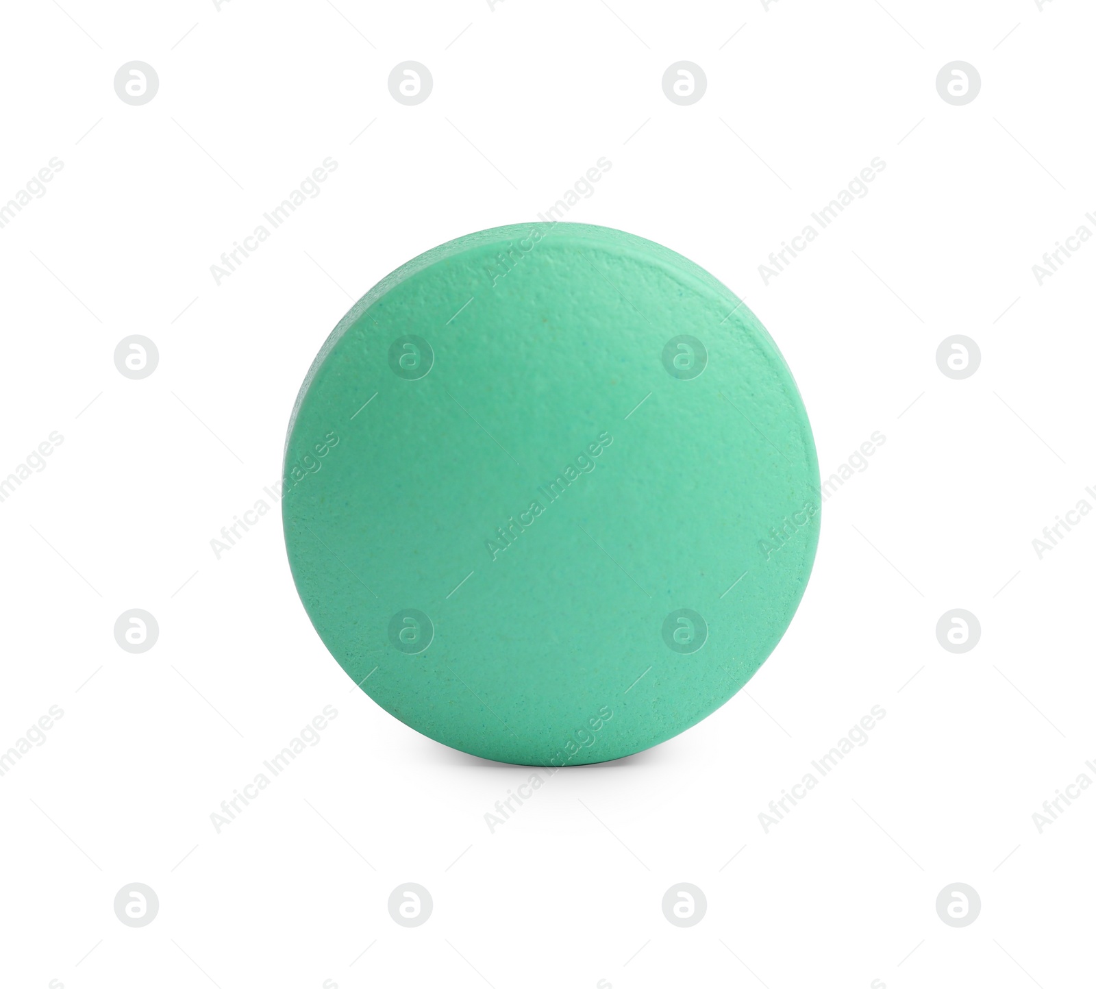 Photo of One light green pill on white background. Medicinal treatment