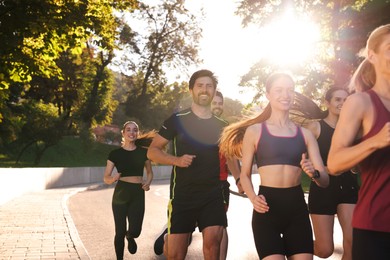 Photo of Group of people running outdoors on sunny day