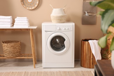 Photo of Stylish laundry room with modern washing machine. Interior design