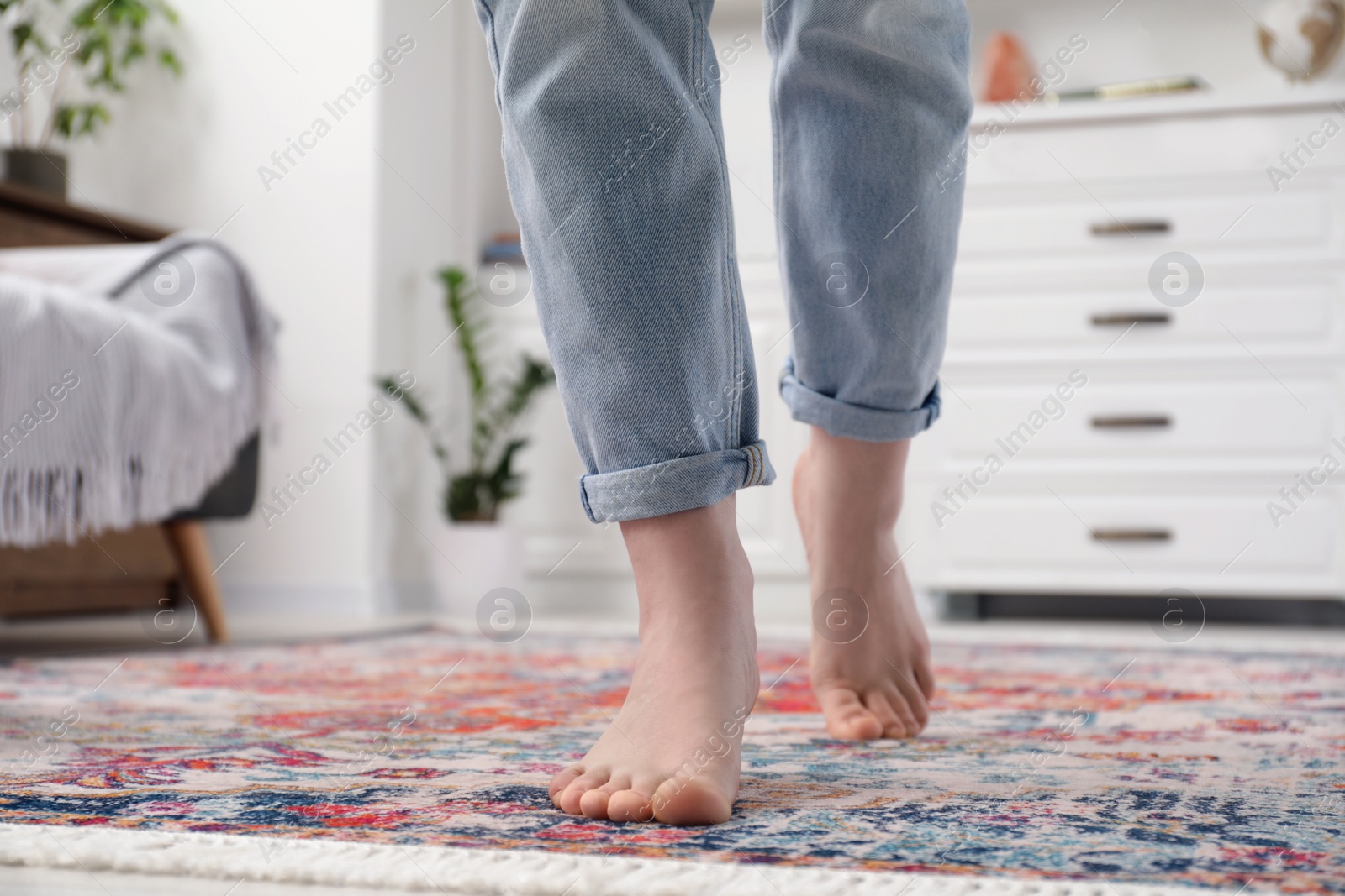 Photo of Woman standing on carpet with pattern in room, closeup