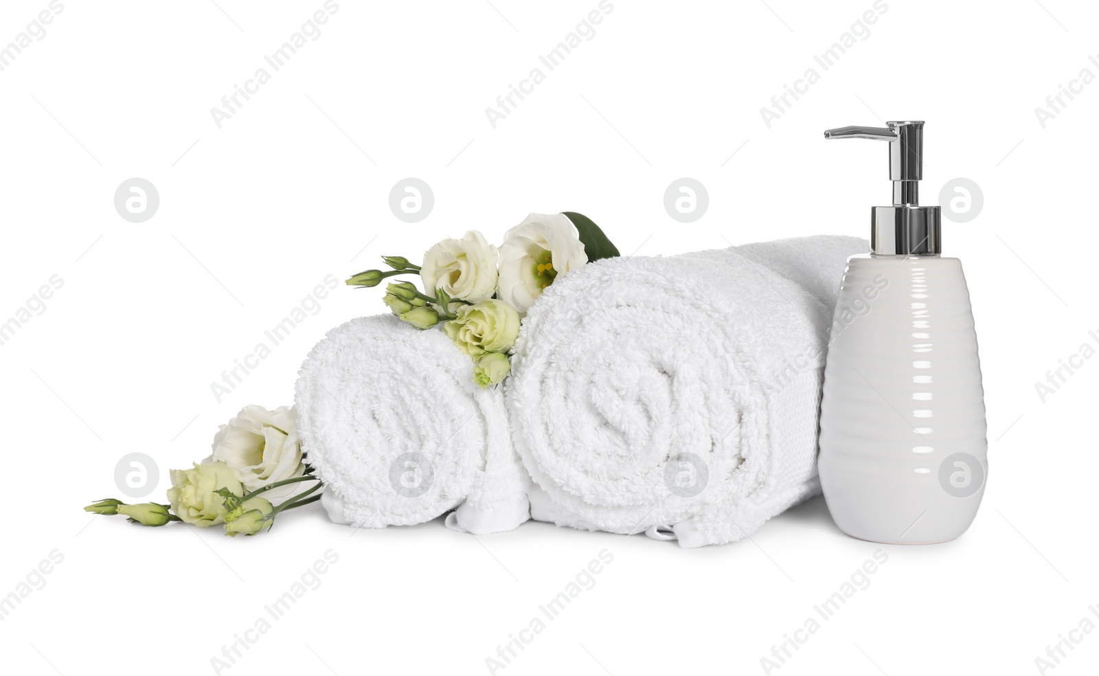 Photo of Clean soft towels with flowers and soap dispenser isolated on white