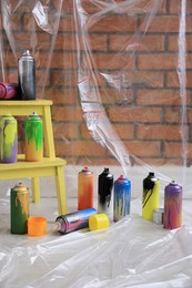 Photo of Used cans of spray paints indoors. Graffiti supplies