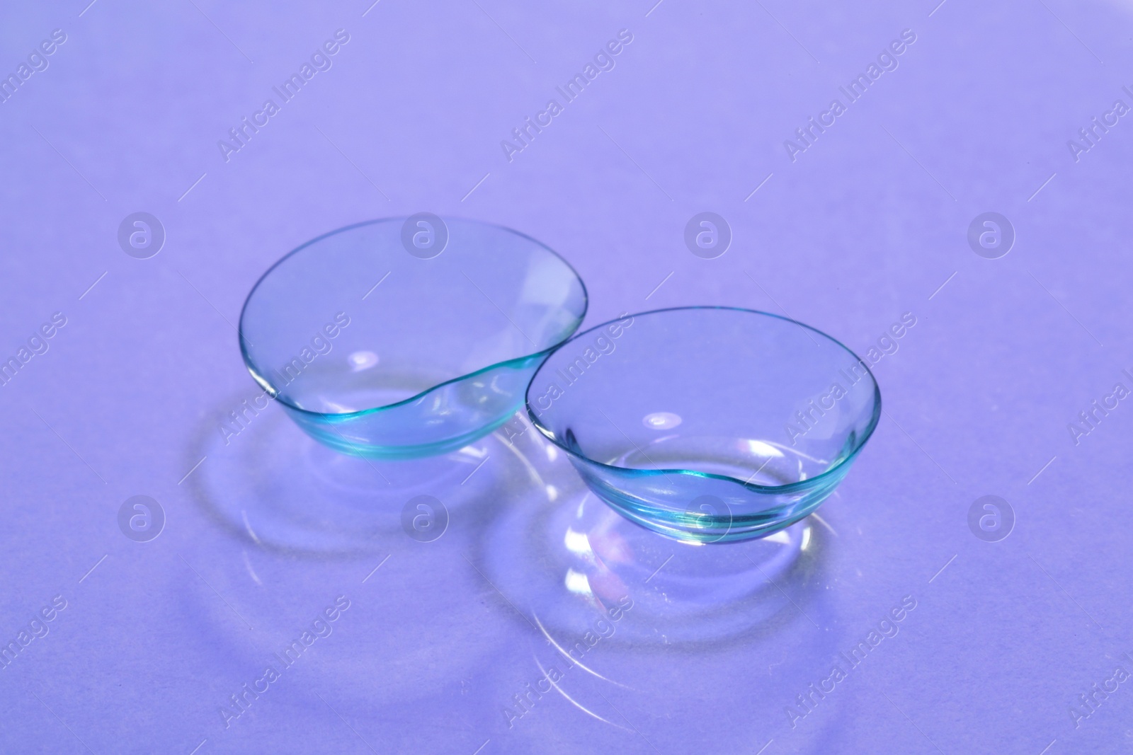 Photo of Pair of contact lenses on violet background