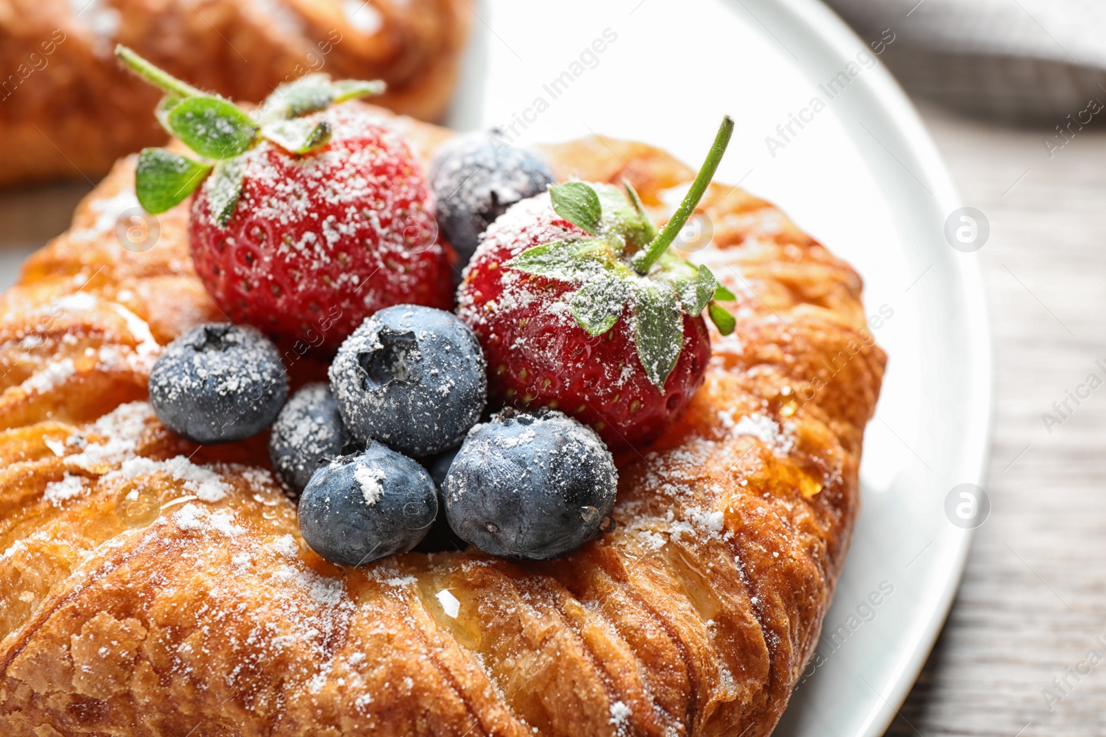 Photo of Fresh delicious puff pastry with sweet berries on plate, closeup