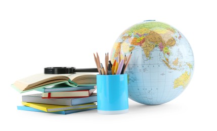 Plastic model globe of Earth, colorful pencils, magnifying glass and books on white background. Geography lesson