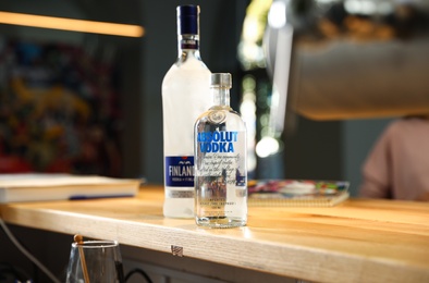 MYKOLAIV, UKRAINE - SEPTEMBER 23, 2019: Bottles of Finlandia and Absolut vodka on wooden counter in bar
