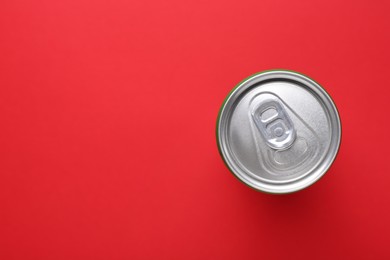 Photo of Energy drink in can on red background, top view. Space for text