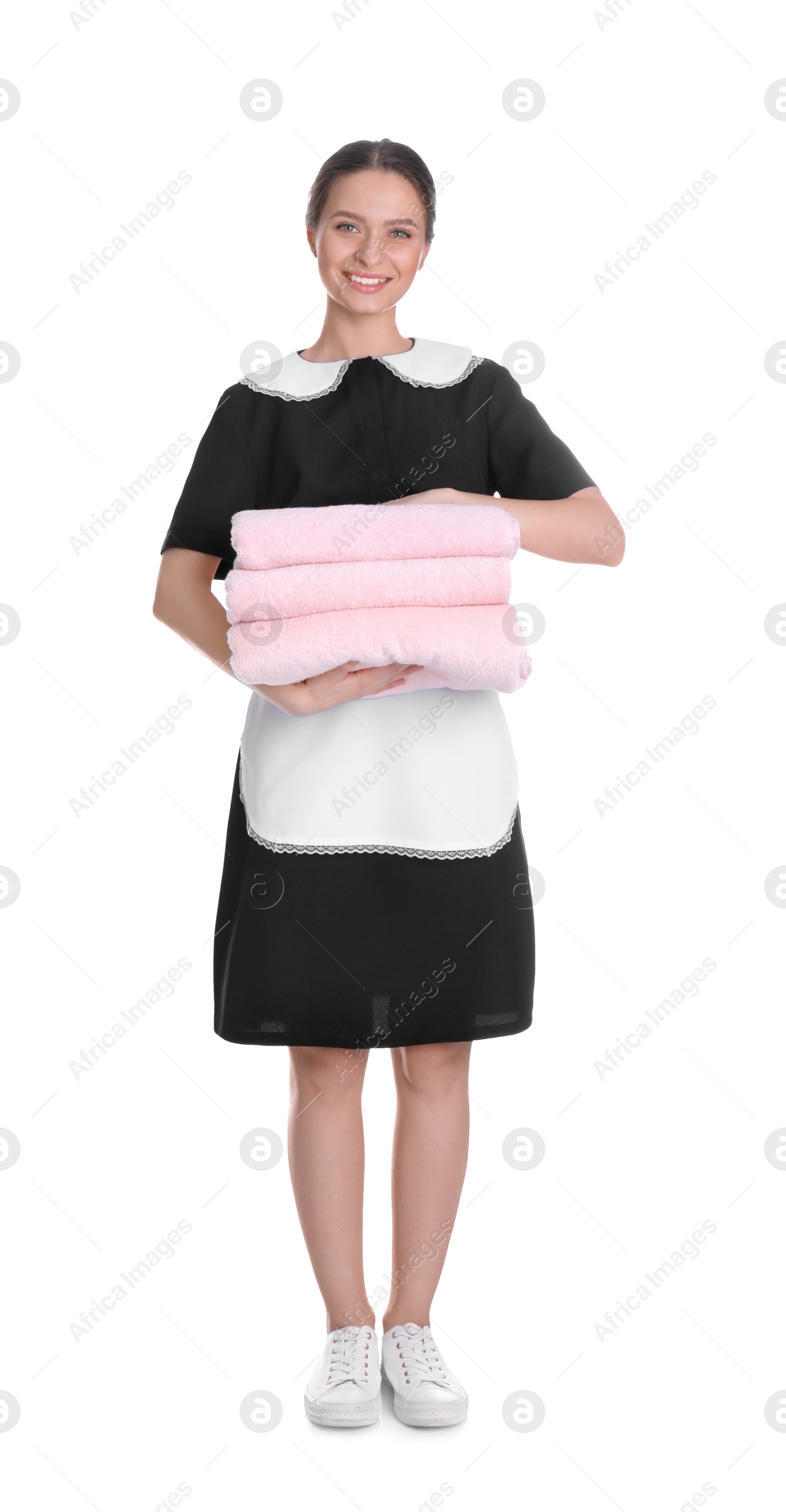 Photo of Young chambermaid holding stack of fresh towels on white background