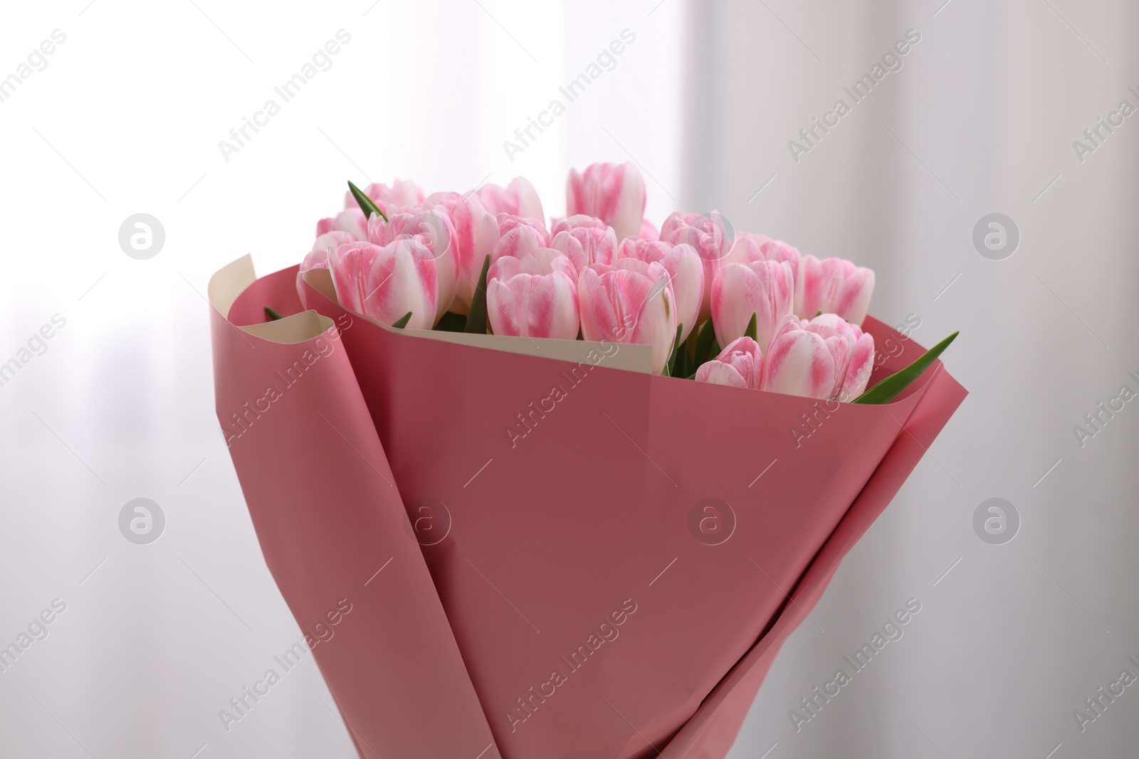 Photo of Beautiful bouquet of fresh pink tulips on blurred background, closeup