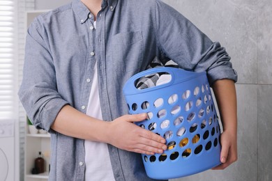 Photo of Man with basket full of laundry in bathroom, closeup