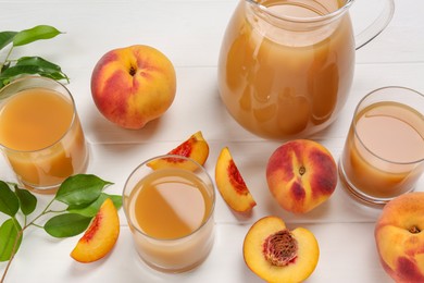 Photo of Delicious peach juice, fresh fruits and leaves on white wooden table