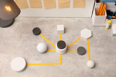 Photo of Business process scheme with geometric figures and stationery on light grey table