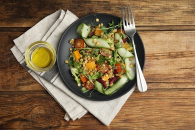 Photo of Delicious salad with lentils and vegetables served on wooden table, flat lay