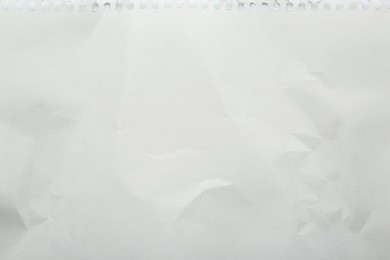 Photo of Blank crumpled notebook sheet as background, top view