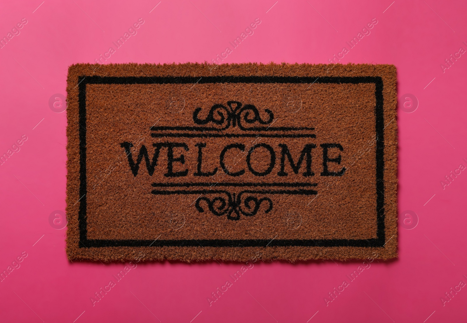 Photo of Doormat with word Welcome on pink background, top view