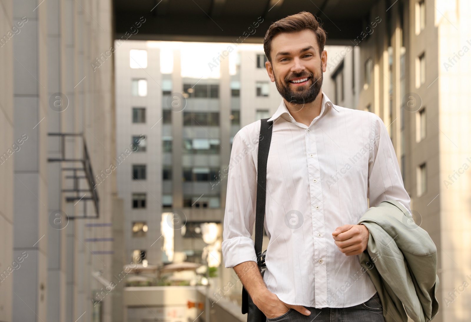 Photo of Handsome man in stylish outfit on city street