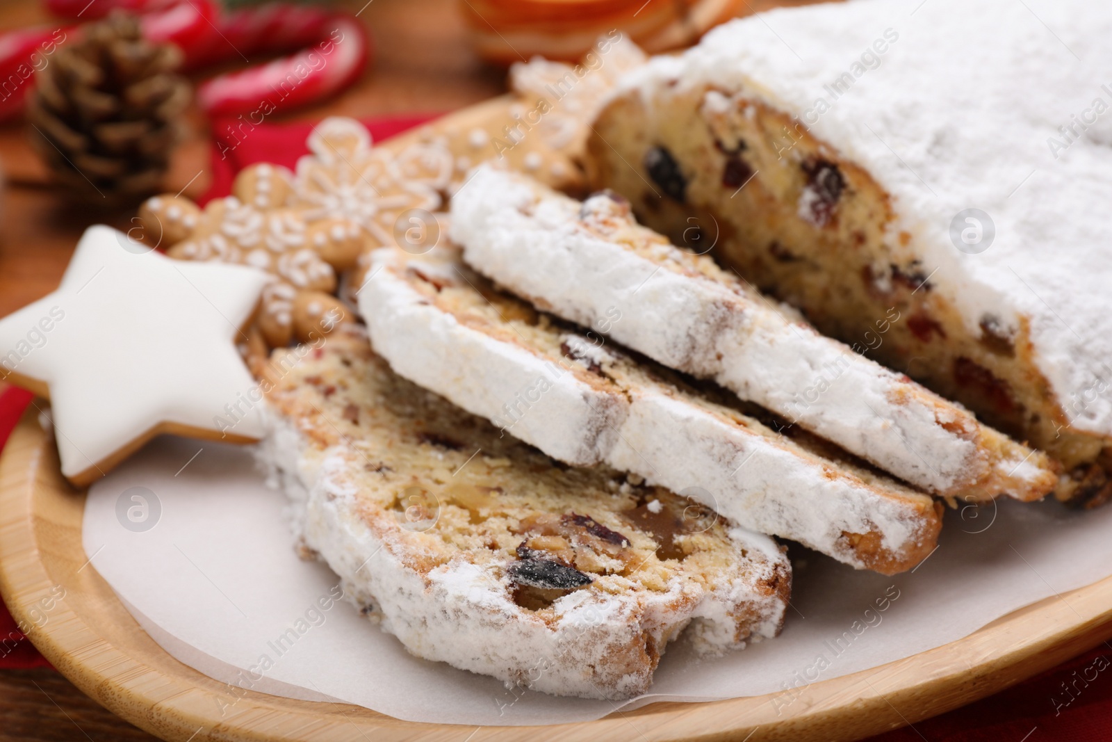 Photo of Traditional Christmas Stollen with icing sugar on plate, closeup