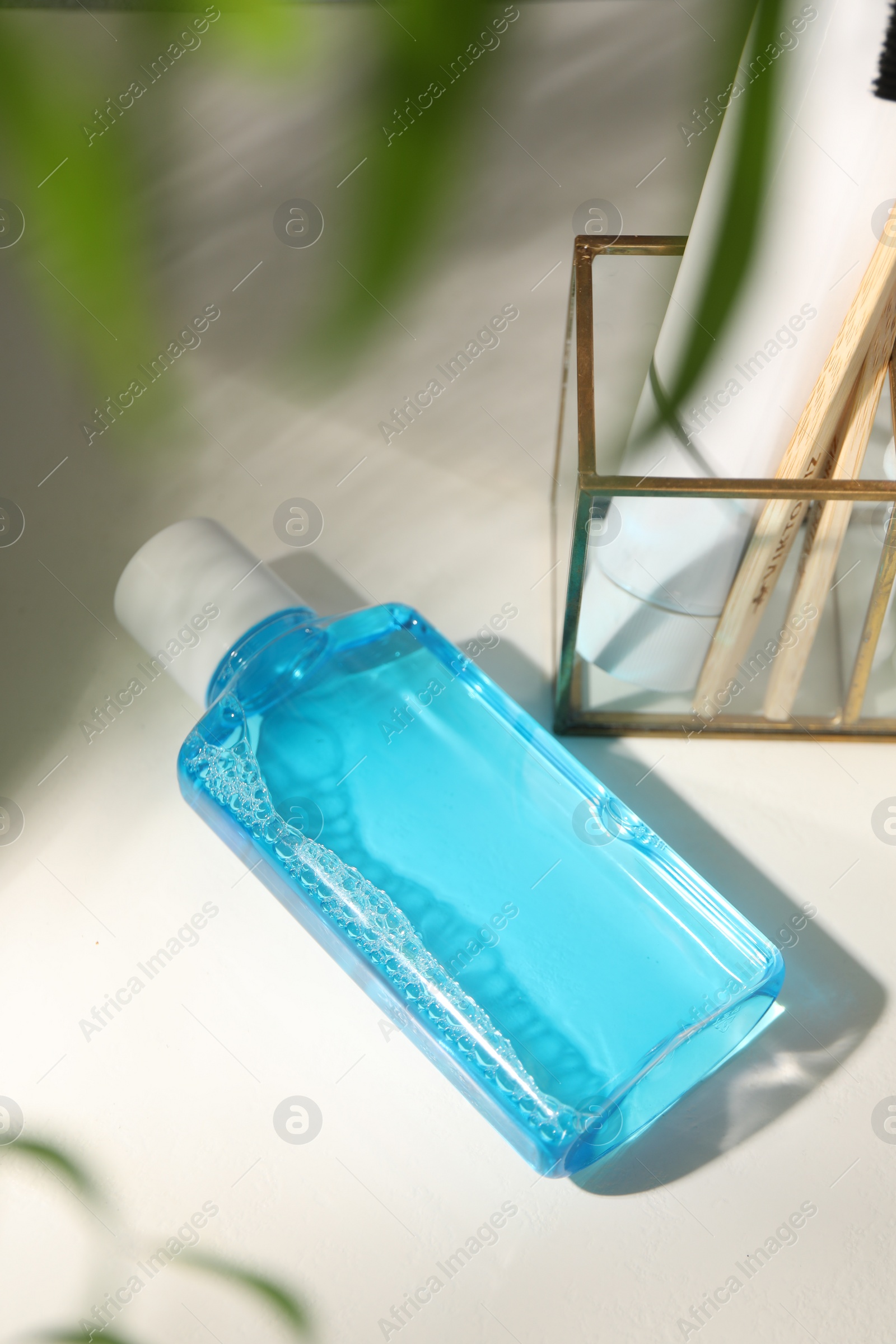 Photo of Bottle of mouthwash on white table in bathroom