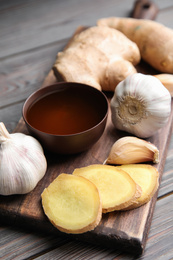 Photo of Fresh garlic and other natural cold remedies on light grey wooden table