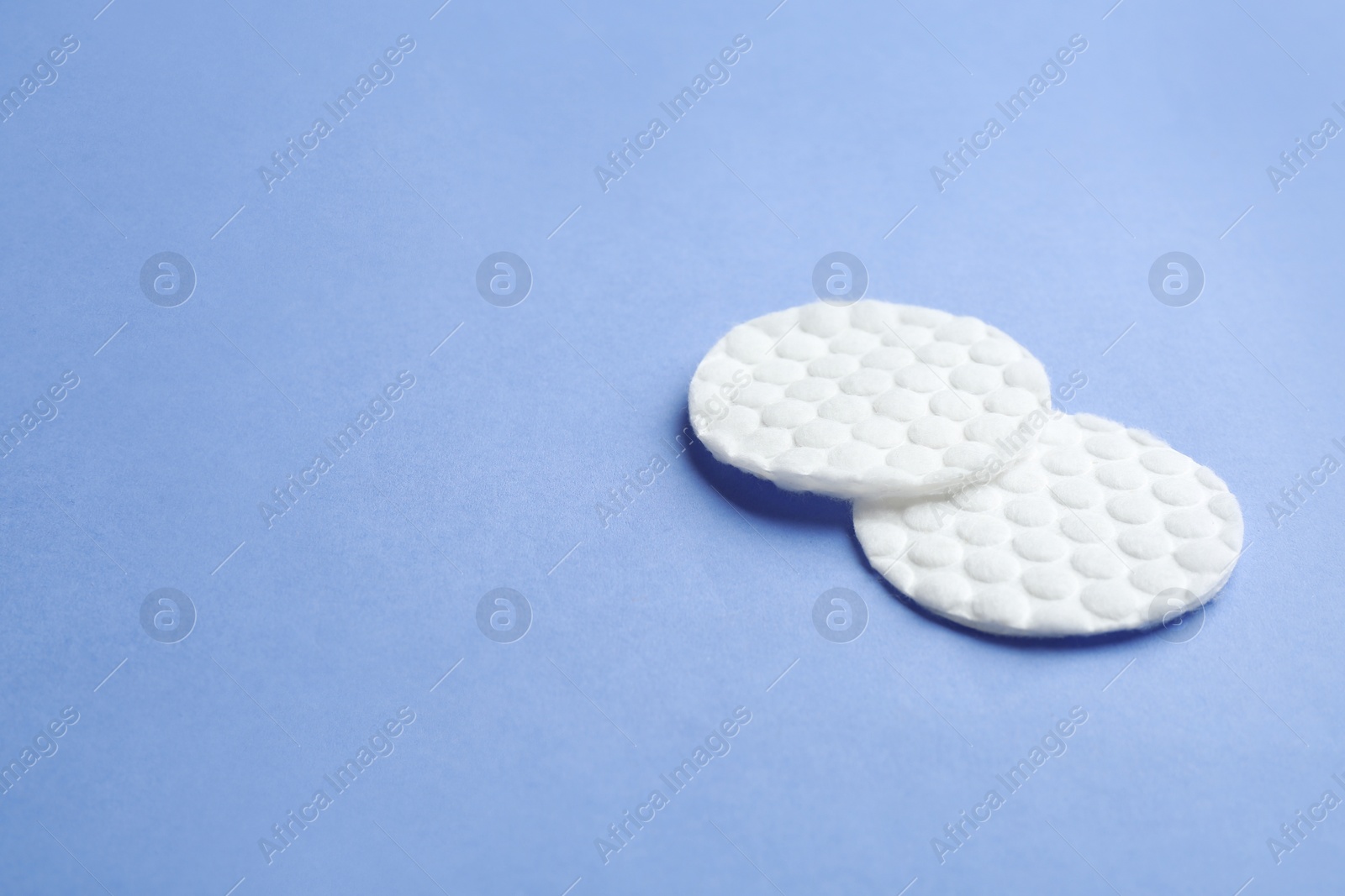 Photo of Cotton pads on color background. Space for text