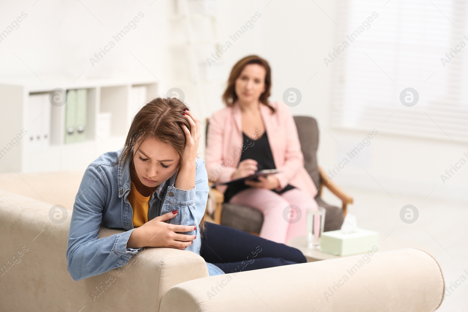 Photo of Psychotherapist working with teenage girl in office