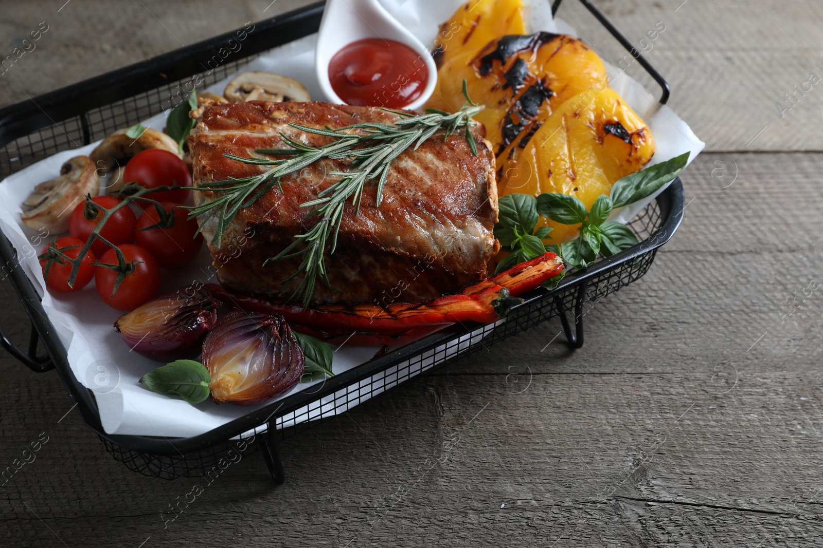 Photo of Delicious grilled meat and vegetables served with sauce on wooden table