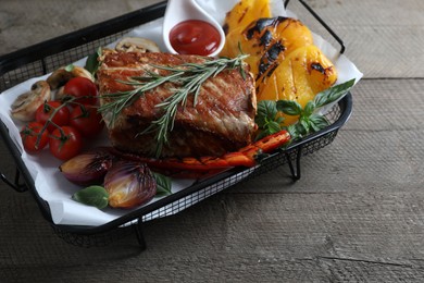 Photo of Delicious grilled meat and vegetables served with sauce on wooden table