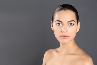 Photo of Portrait of beautiful young woman and space for text on grey background. Cosmetic surgery concept