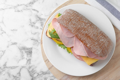 Photo of Tasty sandwich with ham on white marble table, top view
