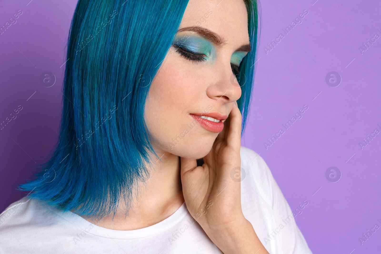 Photo of Young woman with bright dyed hair on lilac background, closeup