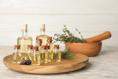 Different essential oils in glass bottles on table